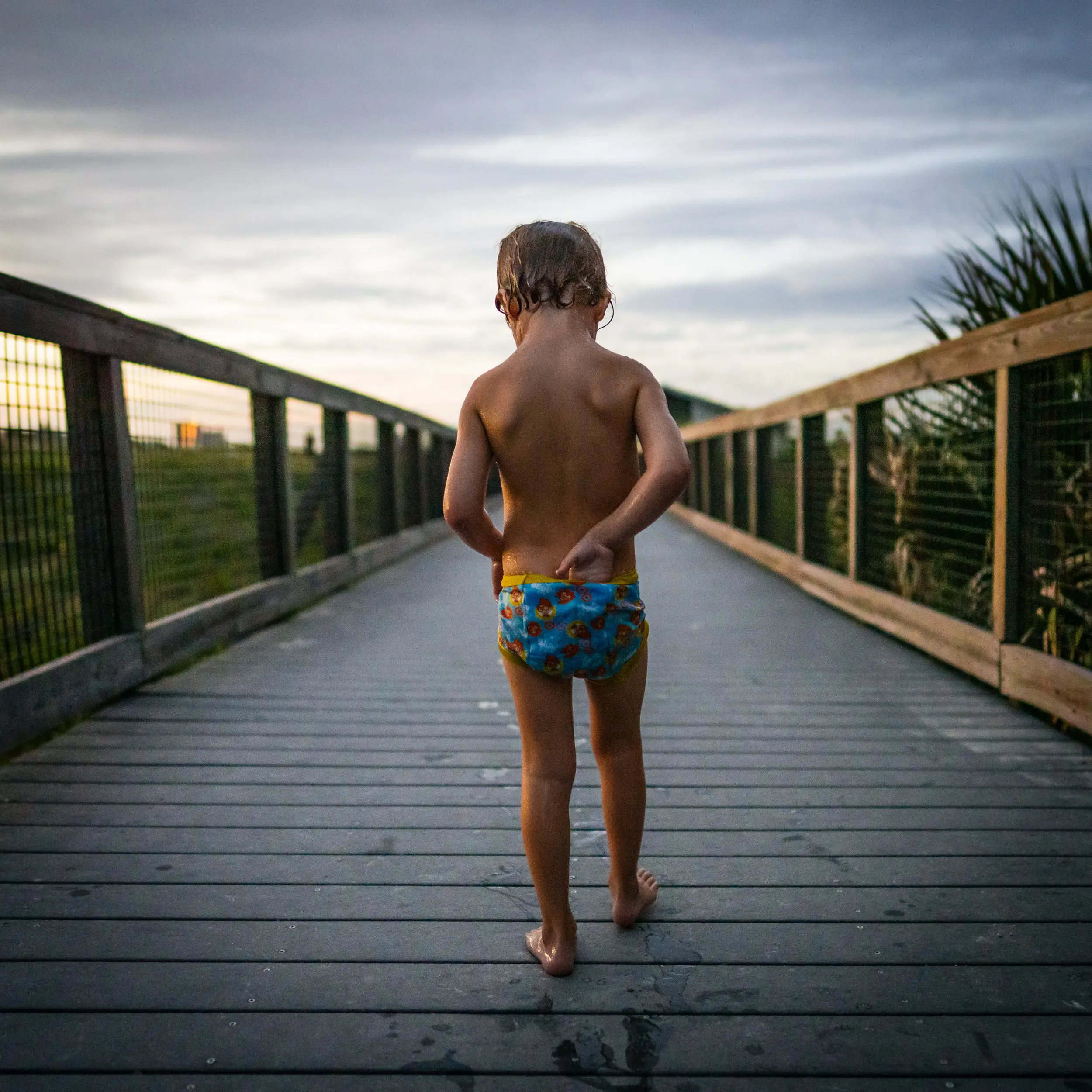 A child walking down a beach boardwalk.