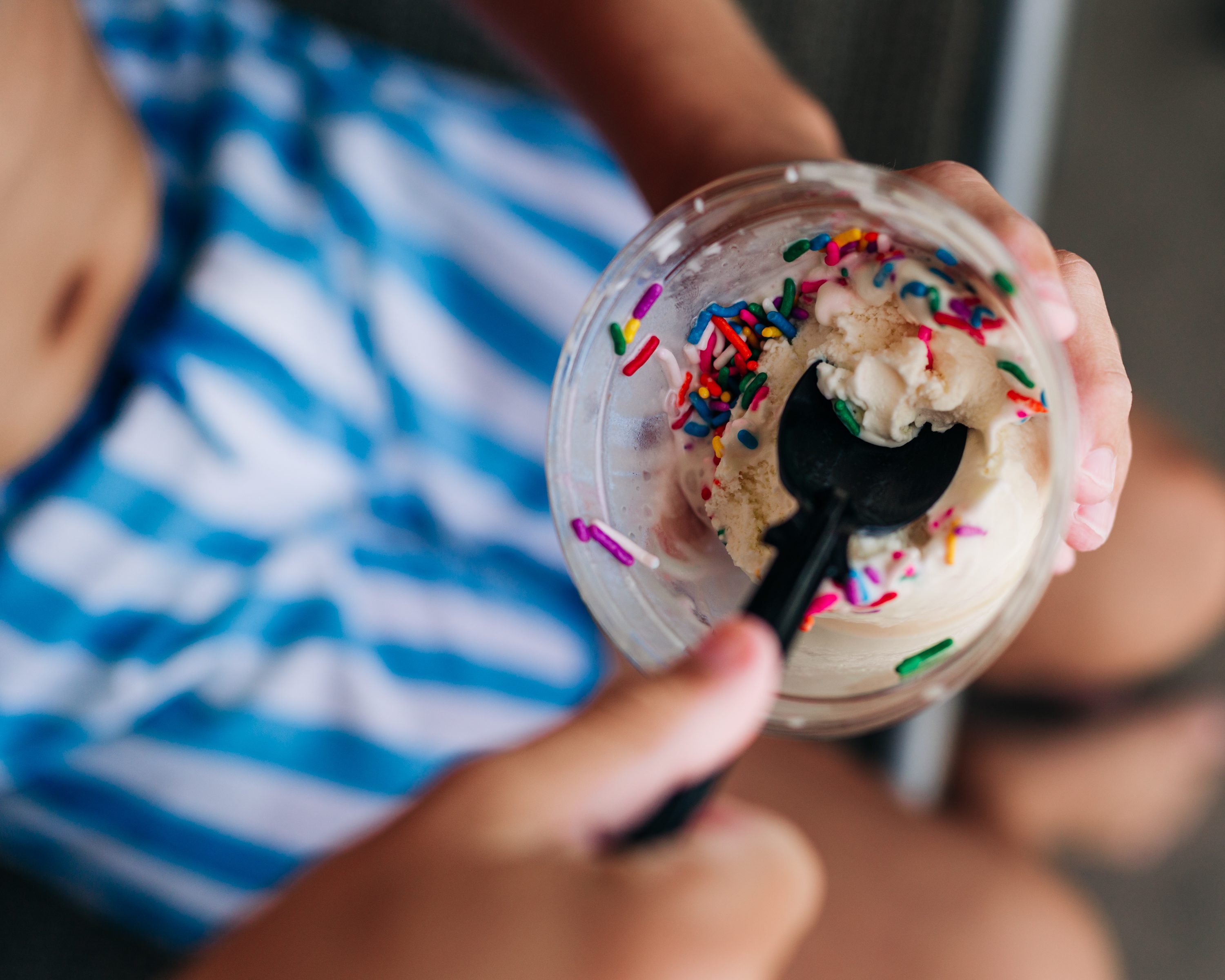 Close-up of a child eating ice cream with colorful sprinkles.