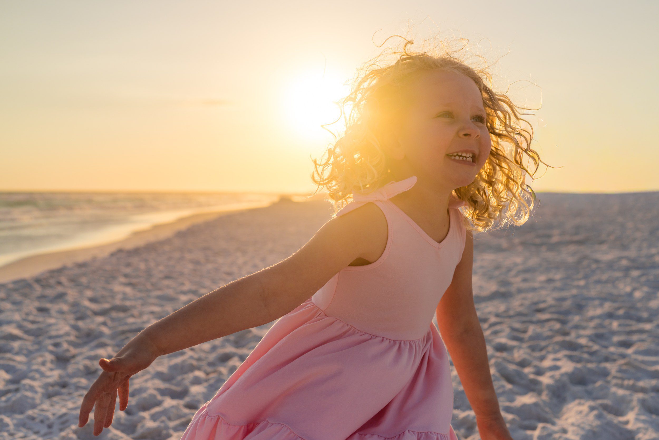 Child laughing and playing during a relaxed beach family photography session